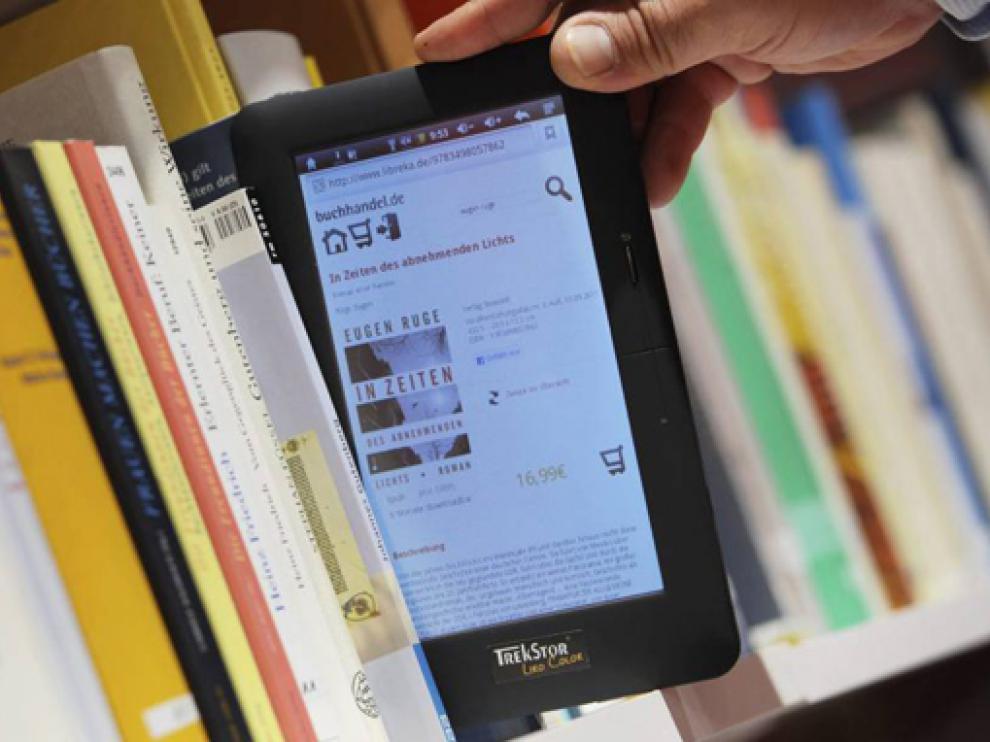 Una persona observa un libro electrónico en un estante de la Feria del Libro de Fráncfort (Alemania).