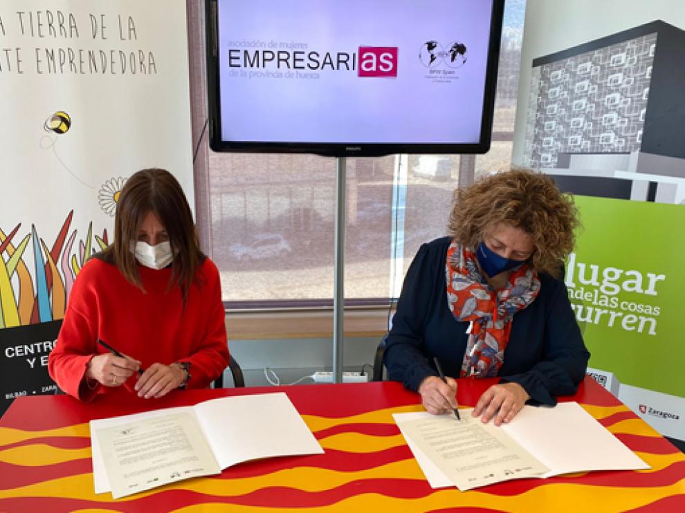 Carmen Fernández y Romy Piñeyroa firman el convenio entre ambas entidades.