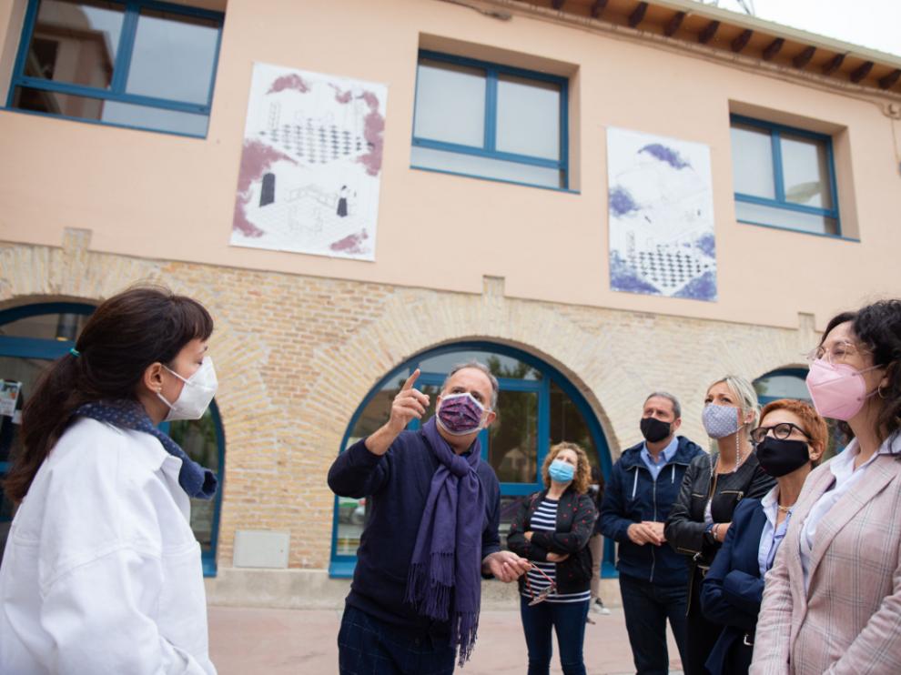 Fotografía de grupo mostrando las ilustraciones instaladas en el exterior de la biblioteca de Sariñena