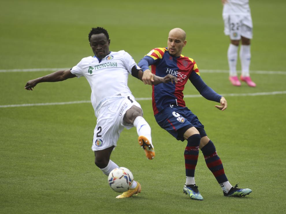Sandro pelea con Djené por hacerse con el balón en el Huesca-Getafe.