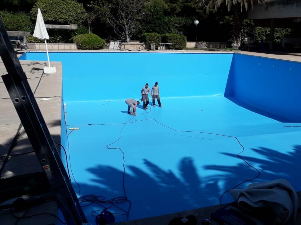 Empleados de Arizón y Gracia trabajando en la rehabilitación y mantenimiento de una piscina.