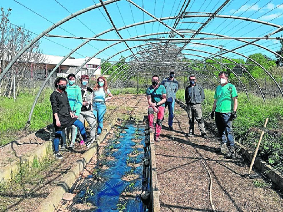 Óscar Olivera, en su invernadero, con David Ferrer y los alumnos del IES Martínez Vargas.