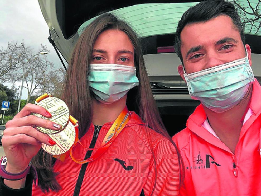 Elena Guiu con su entrenador Eloy Mur y las dos medallas del último nacional.