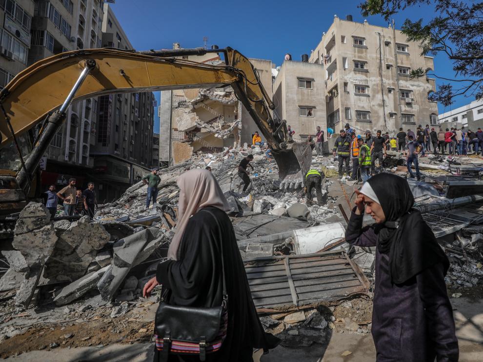 Civiles palestinos realizan labores de búsqueda de personas bajo los escombros de un edificio en Gaza.