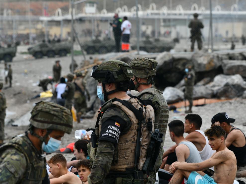 Militares españoles vigilan las devoluciones en caliente que se están haciendo a los inmigrantes que han entrado a Ceuta por Marruecos.