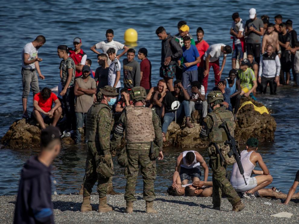 Soldados del Ejército de Tierra observando a un grupo de inmigrantes que llegaban a la costa de Ceuta.