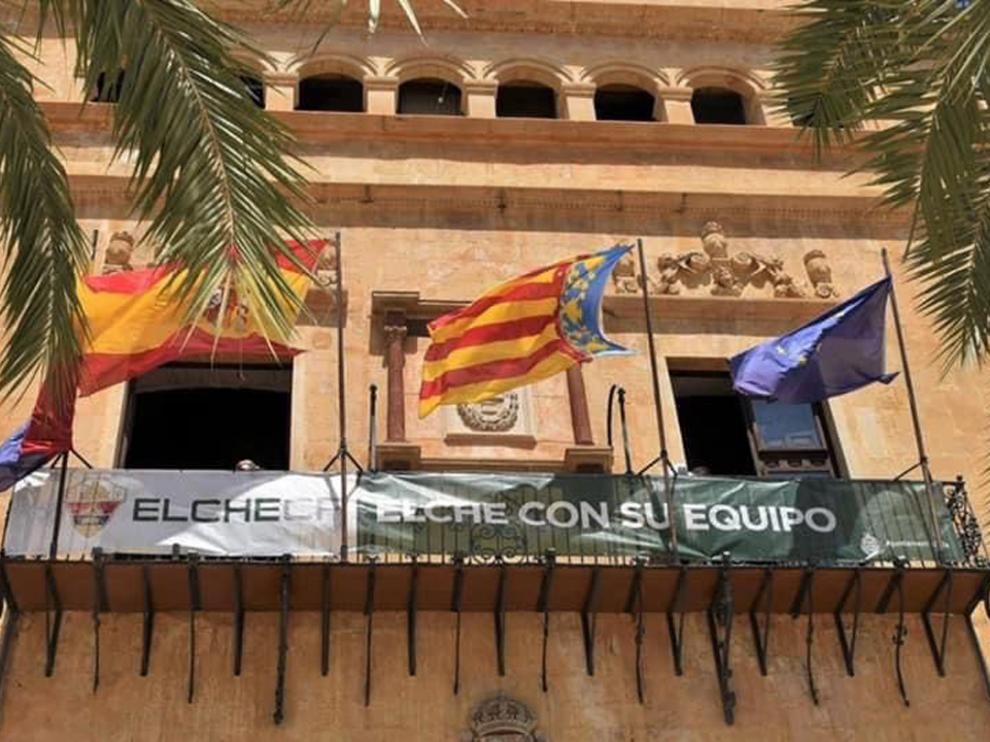 El Ayuntamiento de Elche ha colgado una pancarta de apoyo al equipo en su balcón.