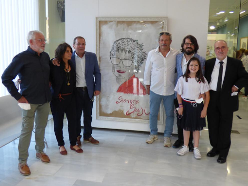Marina Abarca (izda.), con el resto de la familia de Susi Lachén junto al retrato que preside la exposición.