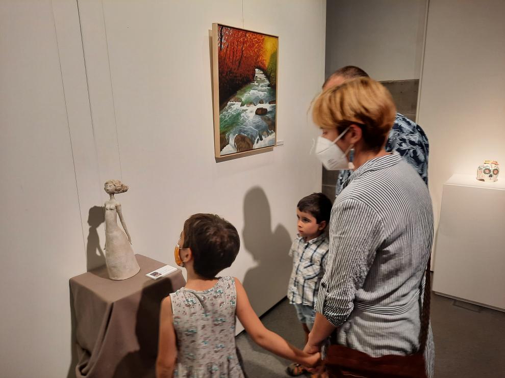 Una familia visitando la exposición en el Espacio Pirineos.