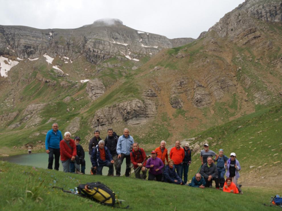 El grupo, frente al ibón y el paisaje montañoso al fondo.