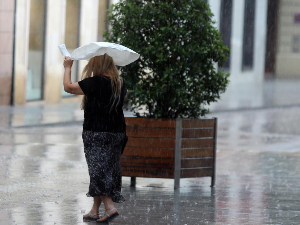 Una señora se resguarda de la lluvia con una bolsa de plástico.