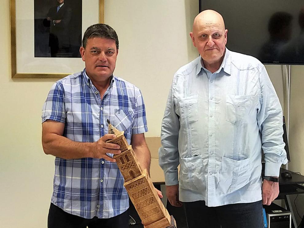 Leontxo García firmó en el libro de honor del ayuntamiento de Alcubierre y su alcalde le entregó una reproducción de la torre mudéjar de la iglesia