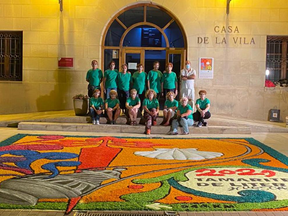 Grupo de alfombristas junto a la alfombra conmemorativa del Año Jacobeo 2021, en la plaza de España de Tamarite.