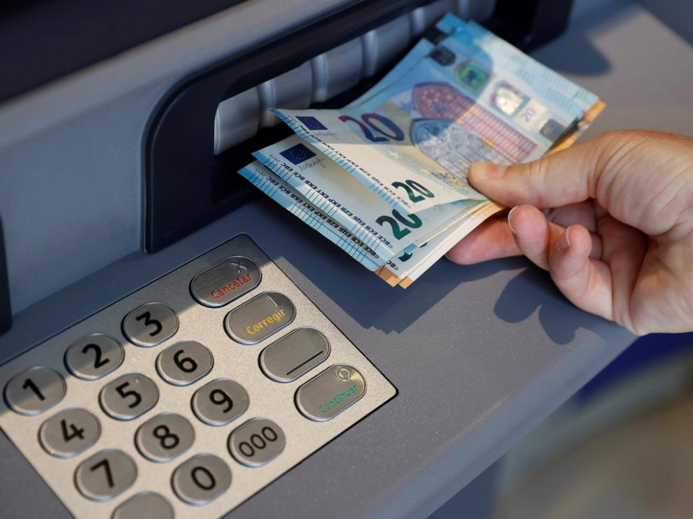 Una persona saca dinero de un cajero de una entidad bancaria