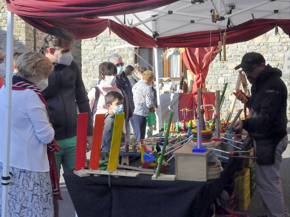 Vecinos y visitantes de Villanúa, junto a varios puestos de la feria.