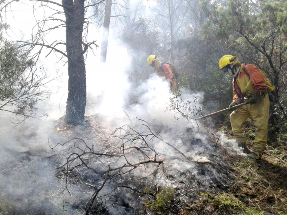 Trabajos de una cuadrilla de bomberos en la extinción de un incendio forestal en Aragón