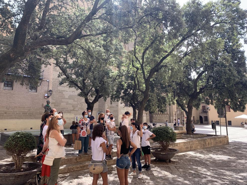Grupo de turistas frente al Ayuntamiento de Huesca en una visita guiada a la ciudad