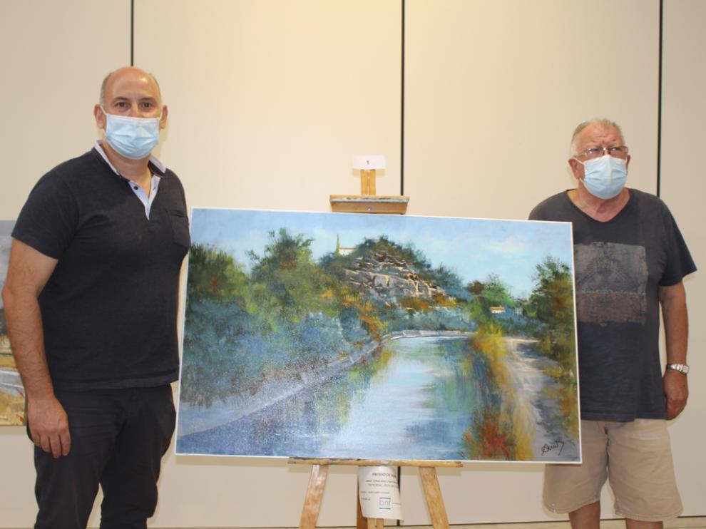 Juan Carlos García y Javier Campo posaron con la obra ganadora, titulada ‘115 años del Canal de Aragón y Cataluña’.