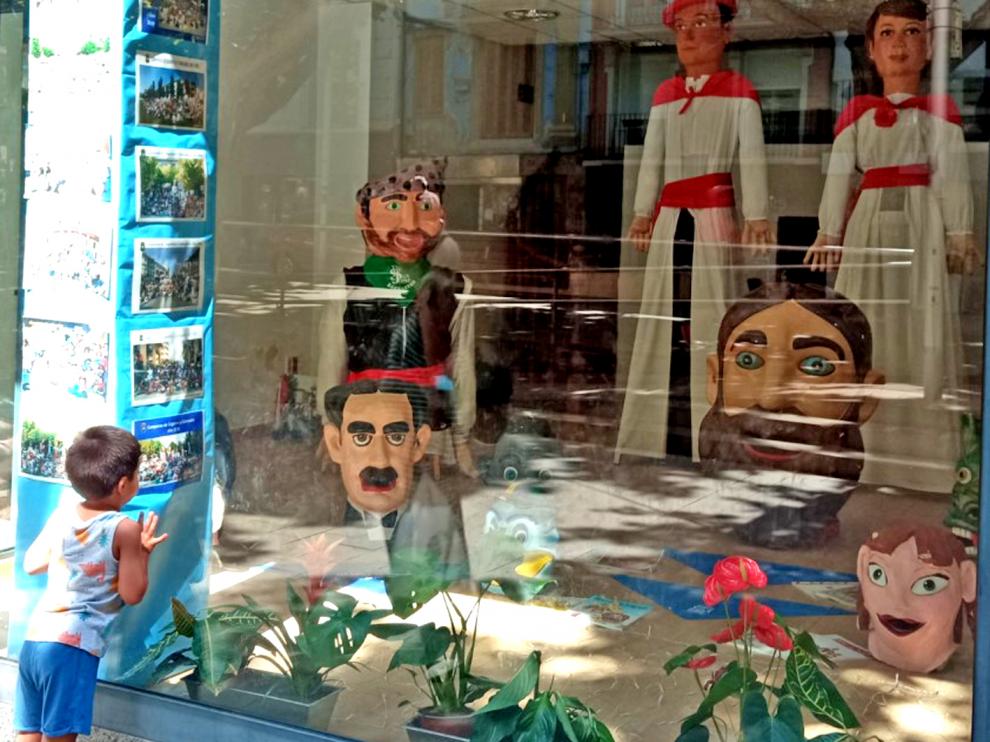 Un niño mira los Los cabezudos y gigantillos en la antigua Sastrería Borruel