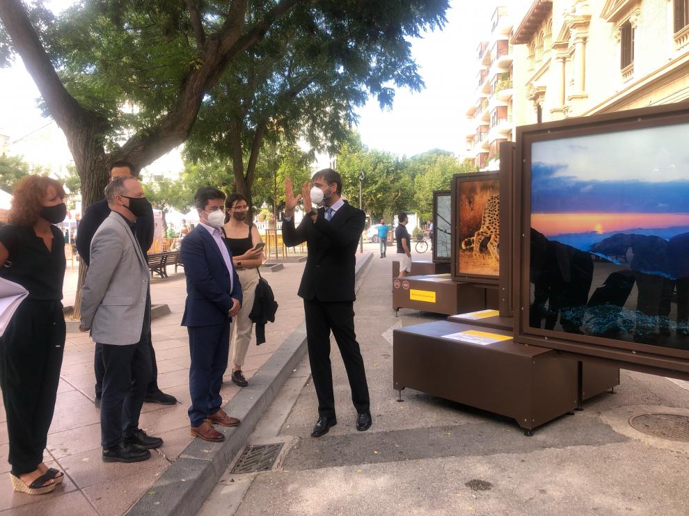 El comisario de la muestra (derecha), explicando las fotografías al alcalde y las autoridades.