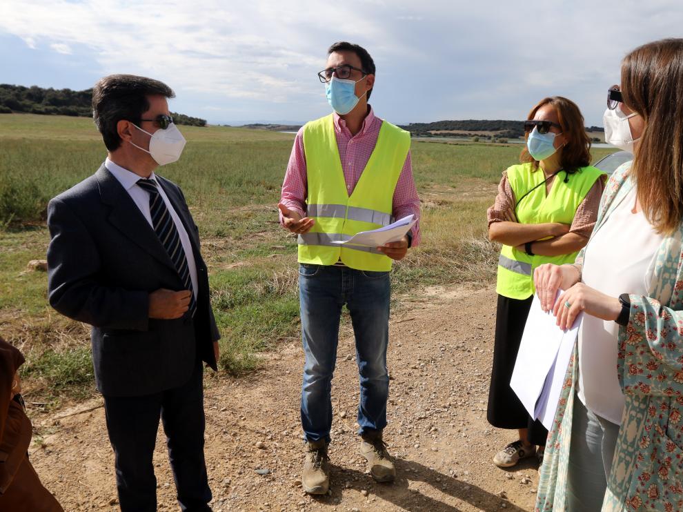 Luis Felipe, el ingeniero David Ortega y María Rodrigo con el embalse de Valdabra al fondo.