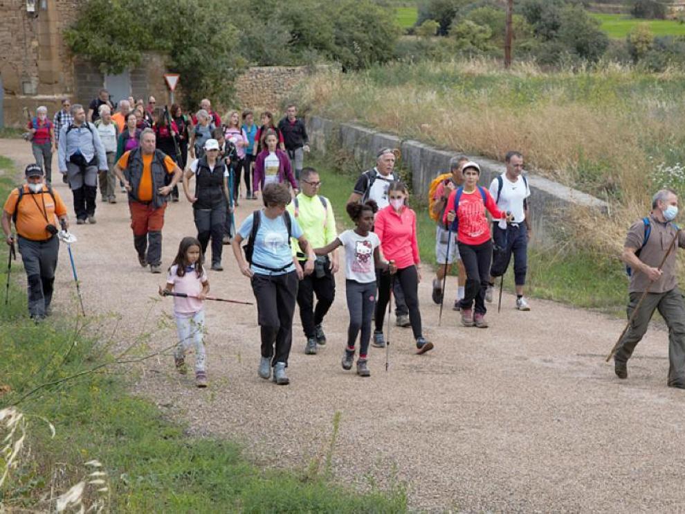 Múltiples integrantes de la caminata a su paso por el municipio de Barluenga, uno de los tramos del recorrido.