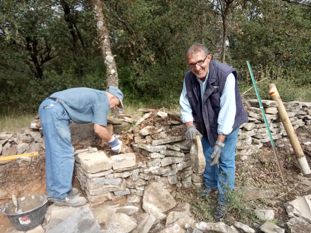 José María, de Casa El Herrero, e Ismael, de Casa El Baile, se afanan en la reconstrucción del muro.