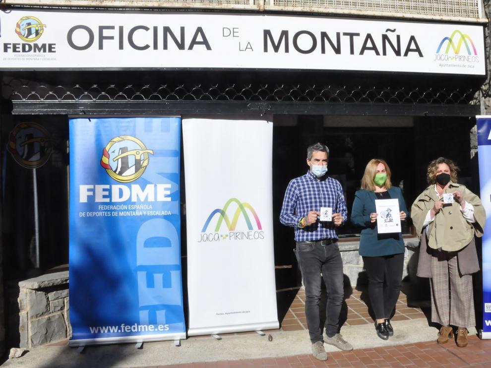 Íñigo Ayllón, Olvido Moratinos y Marian Bandrés muestran el cartel y las pegatinas que se repartirán en comercios de Acomseja.