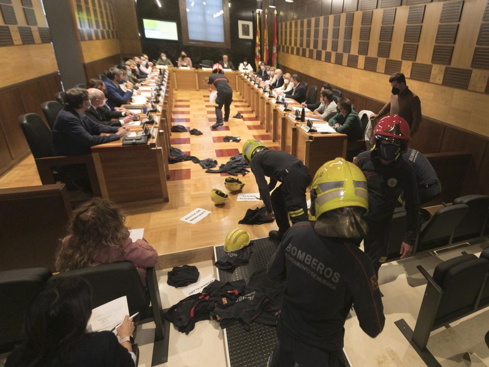 Los bomberos han arrojado algunas prendas y cascos por el suelo del salón de plenos.