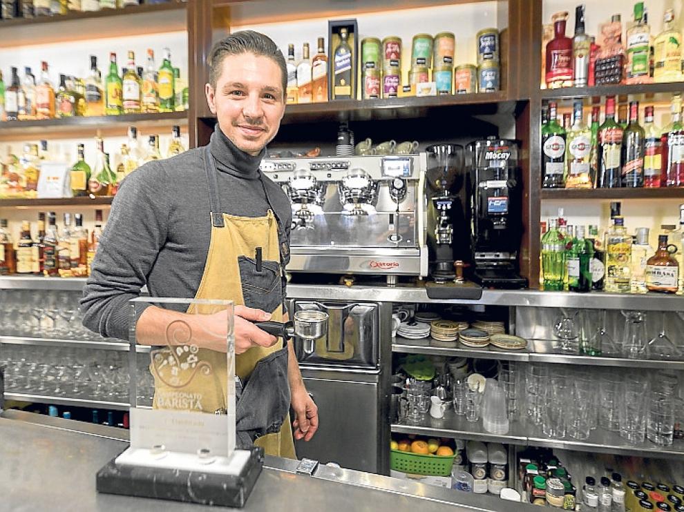 Daniel García, elegido tercer mejor barista a nivel nacional, posa en el bar Rugaca con la placa conmemorativa.