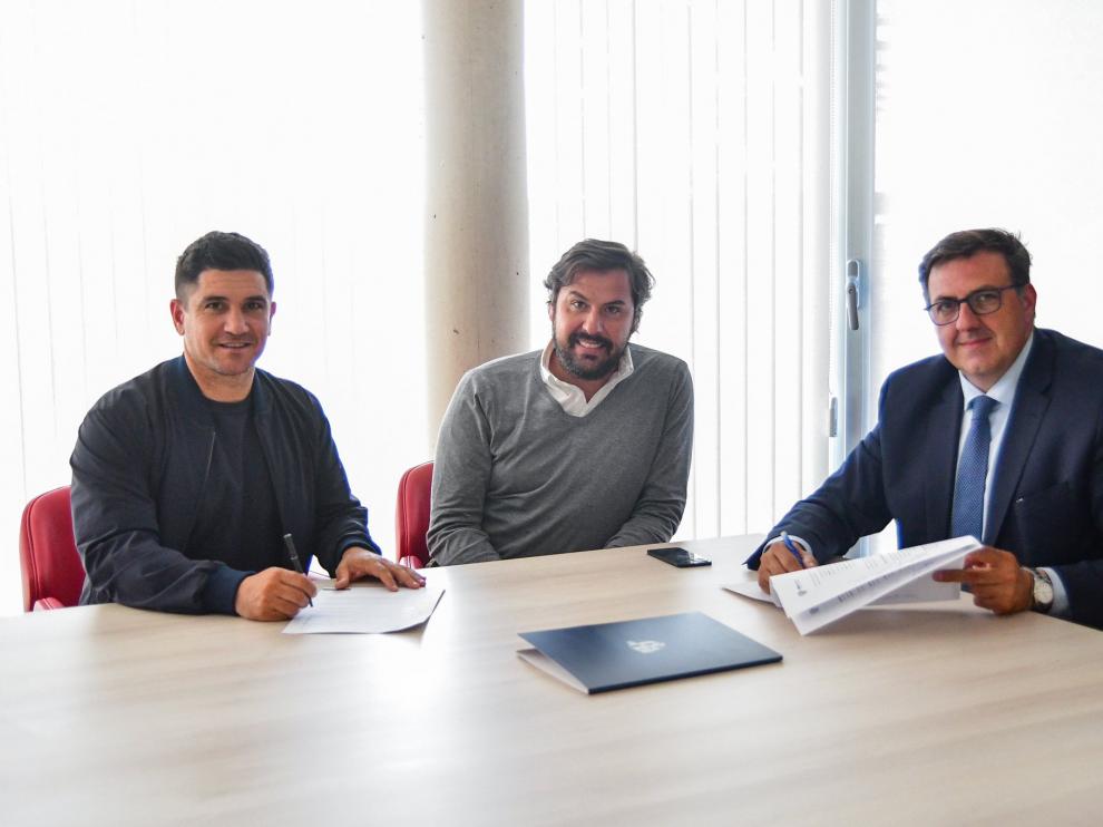 Xisco Muñoz, en la firma de su contrato con el Huesca, con Manolo Torres y Rubén García.