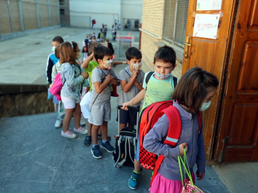 Niños en fila esperan en la puerta del colegio de El Parque instantes antes de entrar en clase.