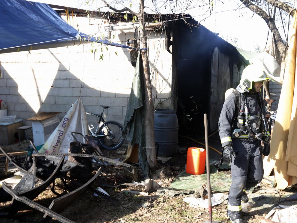 Bomberos junto al chamizo que ha sufrido el incendio en la madrugada de este sábado.