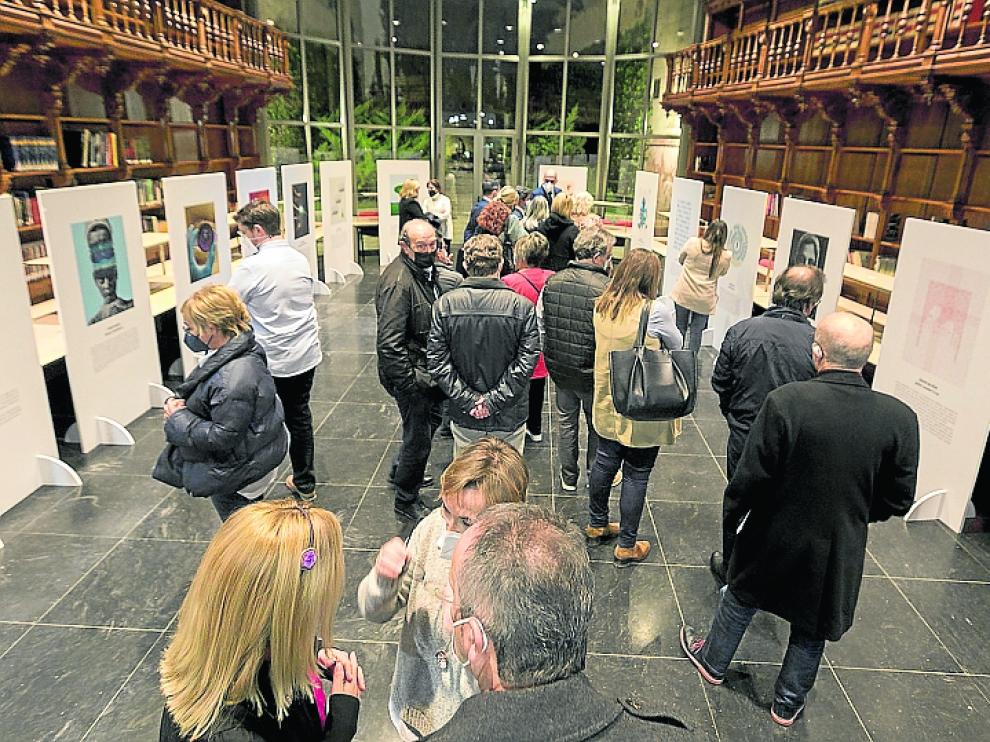 Primeros visitantes ayer en la apertura de la muestra “El Arte de Cuidar”, expuesta en la Biblioteca del centro Ibercaja.