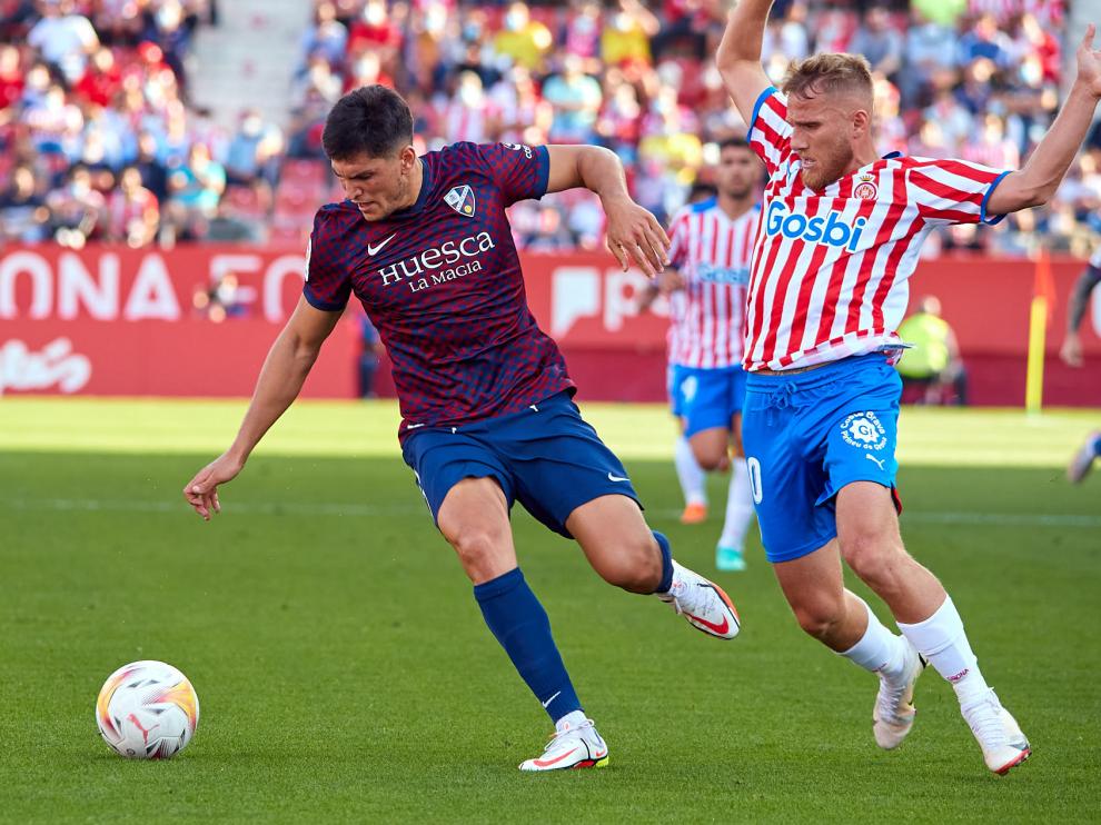 Cristian Salvador pugna con Samu Sáiz en el partido de Gerona.