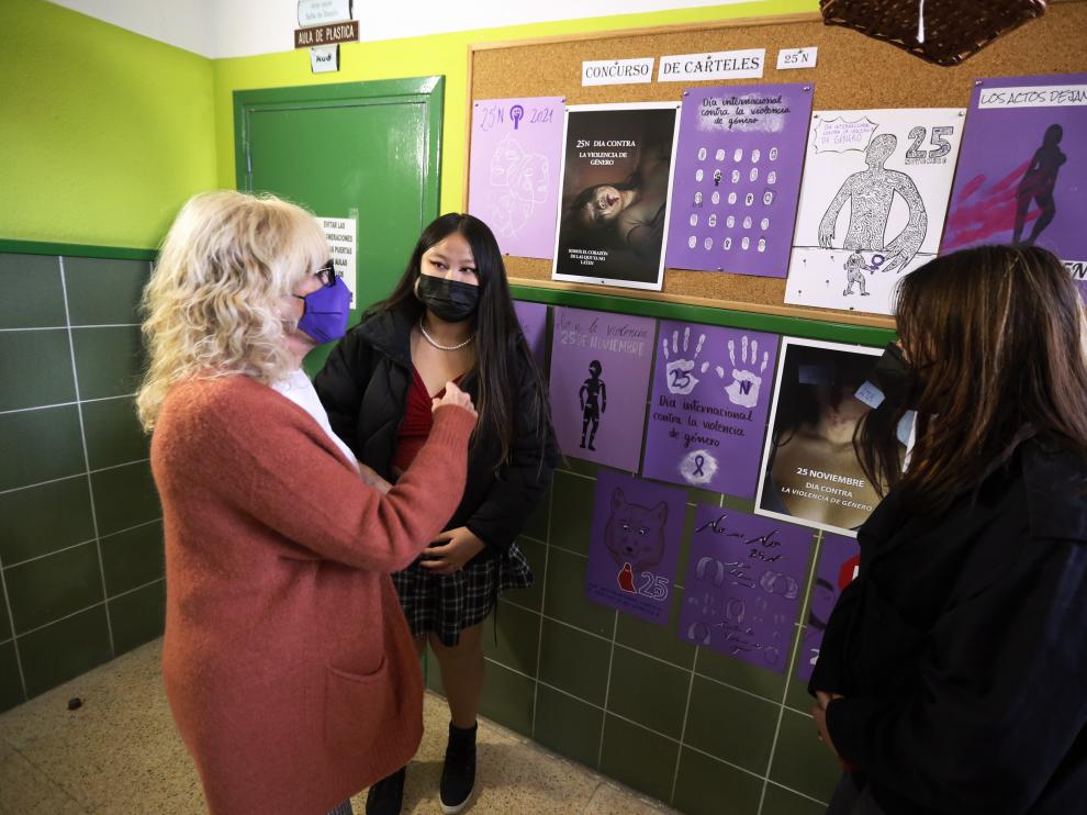 Silvia Salazar conversa con dos alumnas sobre los carteles.