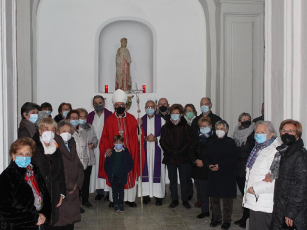 El obispo y los feligreses junto a la talla de Santa Bárbara, durante la jornada de este sábado en la localidad de Azanuy.
