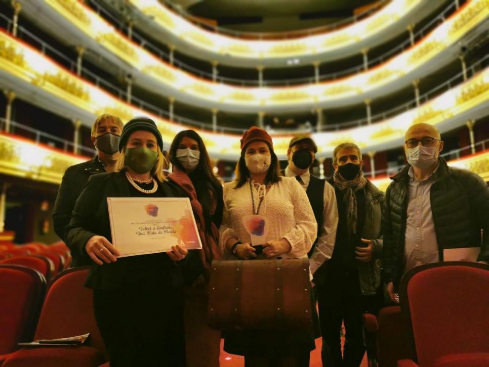 Representantes de Volver a Canfranc muestran el premio y el diploma recibido.