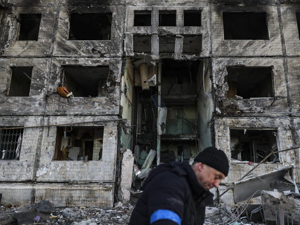Un hombre trabaja en las tareas de limpieza de un edificio bombardeado.