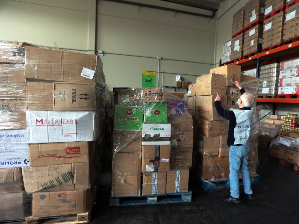 Un voluntario del Banco de Alimentos de Huesca clasifica algunas cajas de material en el almacén.