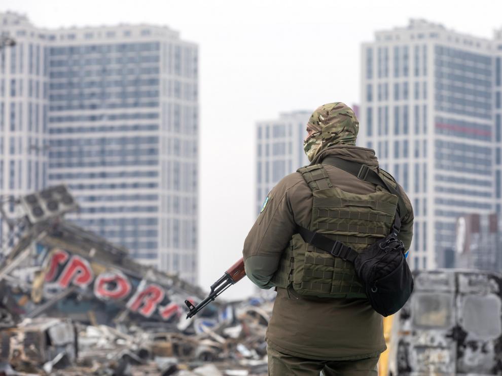 Un militar ucraniano junto a un centro comercial destruido en Kiev.