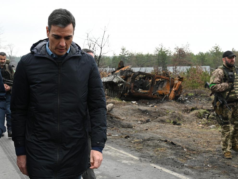El presidente camina cabizbajo tras pasar por una zona en la que son patentes los efectos de los ataques.