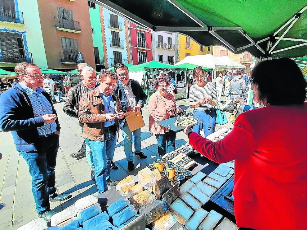 Las autoridades que acudieron a la Feria Agroalimentaria degustan queso en uno de los puestos.