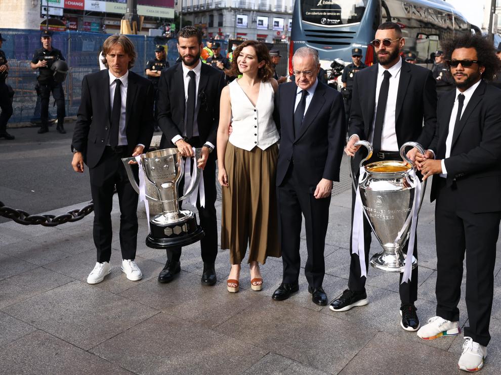 Jugadores del Real Madrid con Isabel Díaz Ayuso posan con la copa de la Champions.