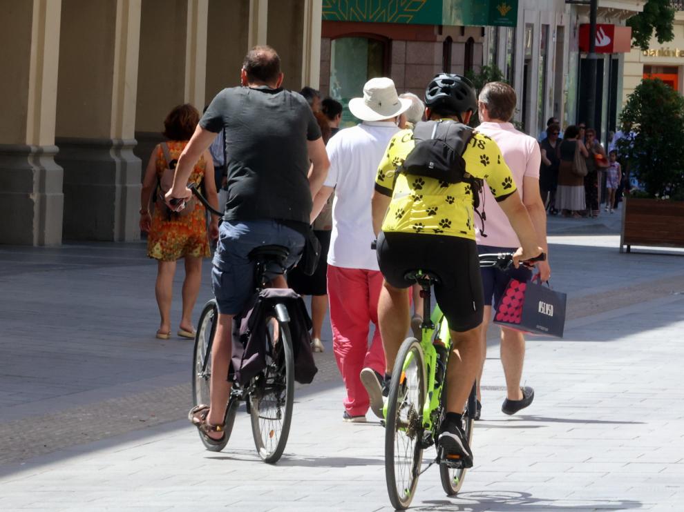 Dos ciclistas entre los peatones en el centro de Huesca.