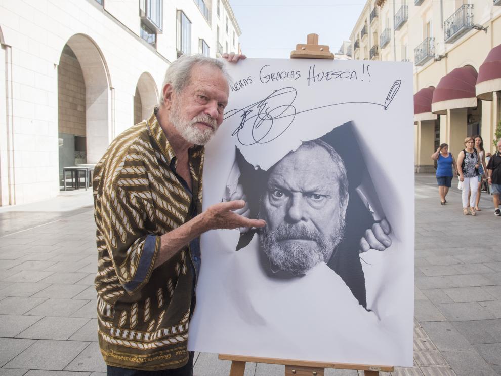 El director Terry Gilliam posa con su retrato en los Porches de Galicia.