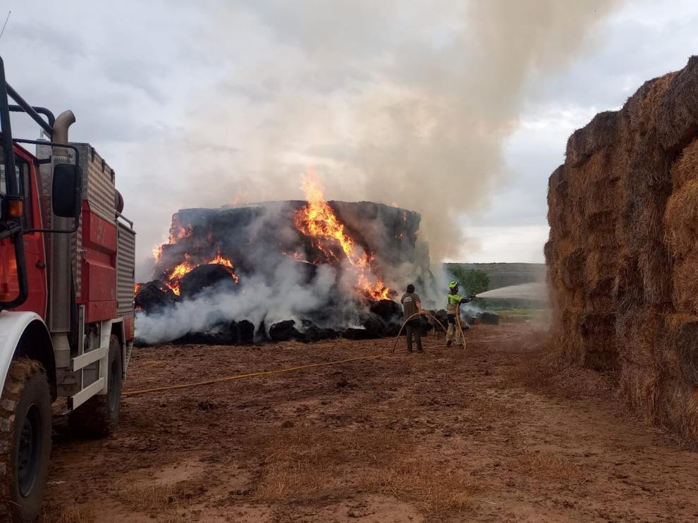 Trabajos de extinción del incendio de pacas de paja en una granja de Chalamera.
