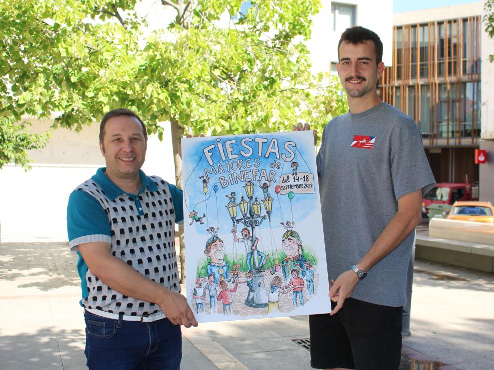 Francis Charles (izda) y Guillermo Monje con el cartel en la plaza de España de Binéfar,