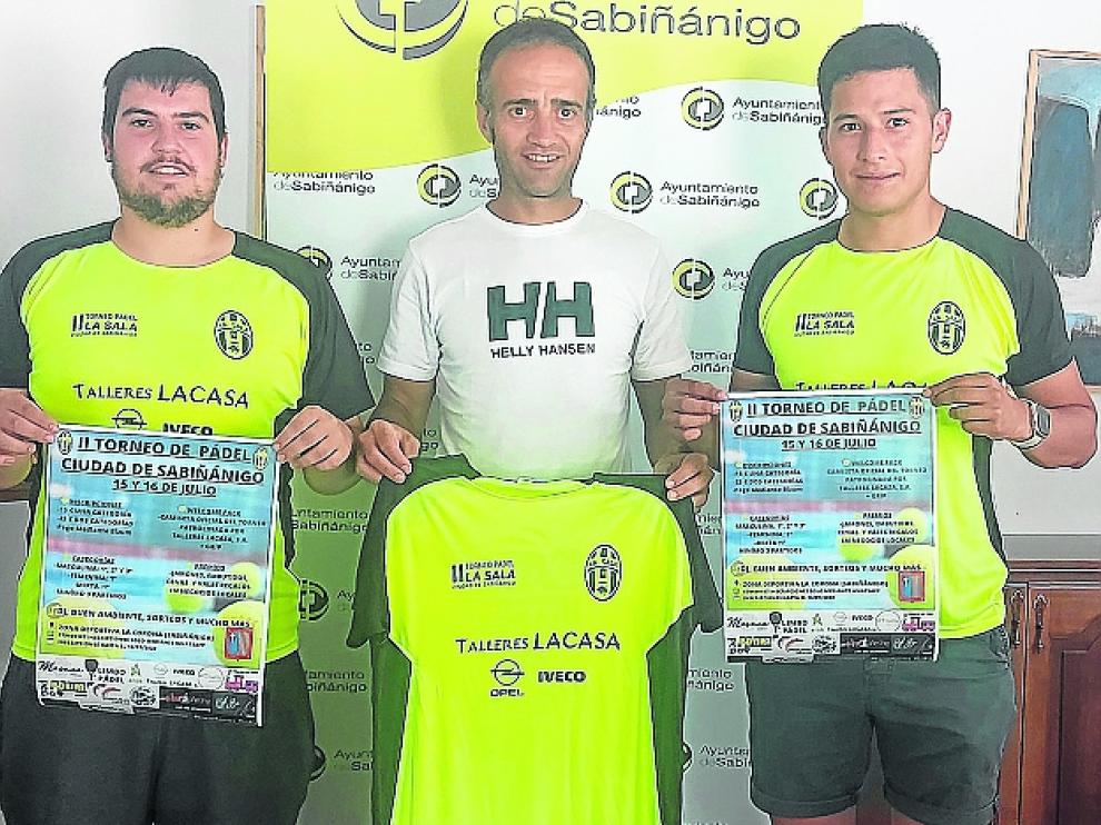 Victor Sedano, Carlos Allué y Maicol Chamorro posan con el cartel y la camiseta del torneo.