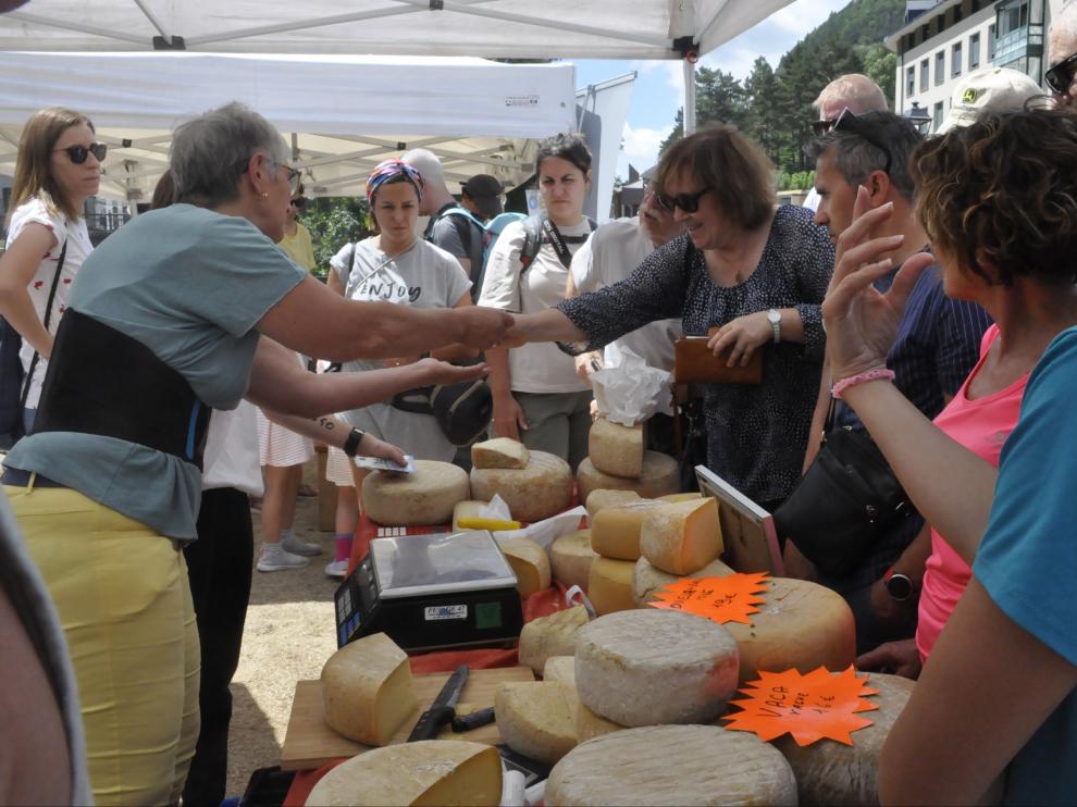 Una mujer compra queso en uno de los puestos de la feria.